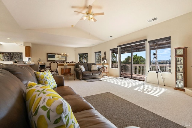 living room with ceiling fan with notable chandelier, vaulted ceiling, and carpet floors