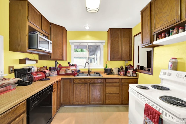 kitchen featuring white range with electric cooktop, sink, and black dishwasher