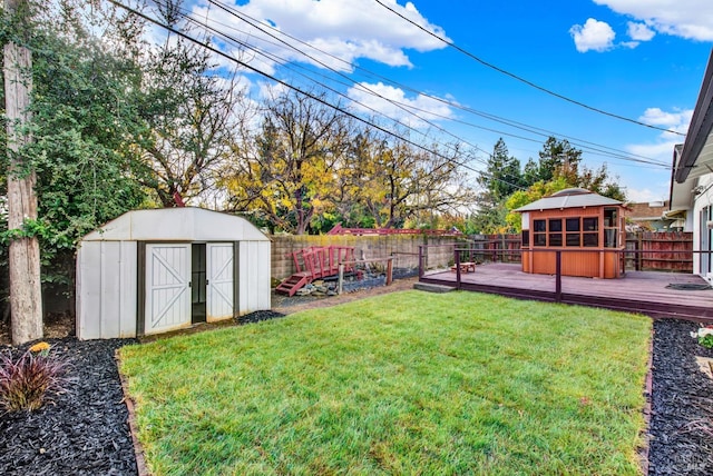 view of yard featuring a storage unit and a wooden deck