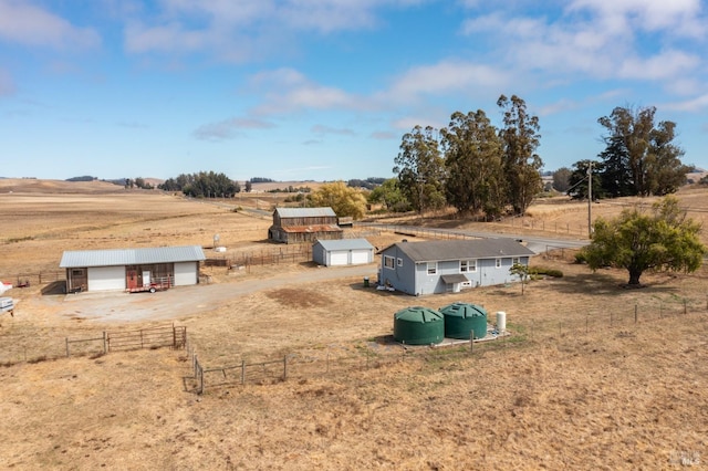 view of yard with an outbuilding, a garage, and a rural view