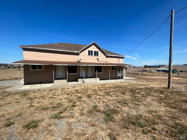 rear view of property featuring a rural view and a patio area