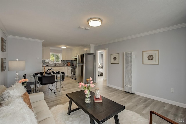 living room with ornamental molding and light hardwood / wood-style floors