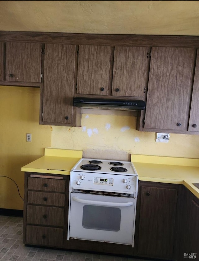 341 Inverness Dr, Vallejo, CA 94589 - kitchen with under cabinet range hood, dark brown cabinetry, light countertops, and white range with electric cooktop