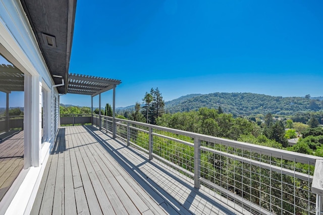 wooden terrace with a pergola and a mountain view