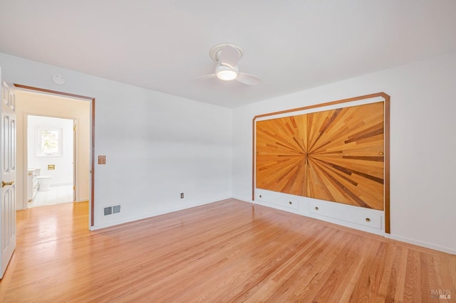 empty room featuring baseboards, visible vents, light wood-style floors, and a ceiling fan