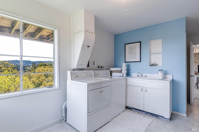 laundry area featuring baseboards, marble finish floor, a sink, cabinet space, and separate washer and dryer