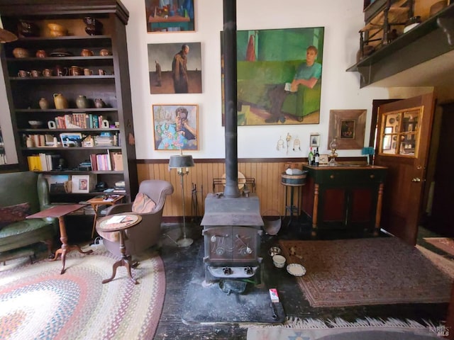 sitting room with wood walls and a wood stove