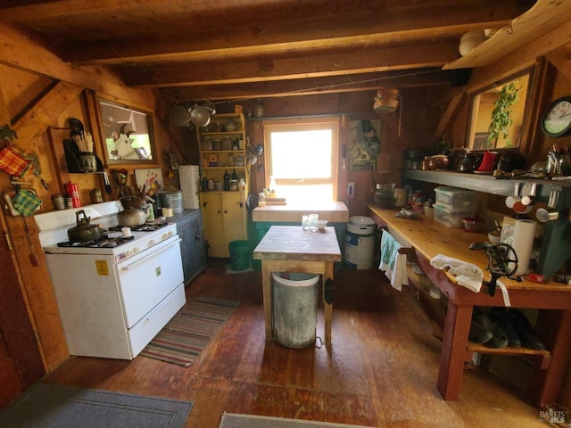 kitchen with wooden walls, beamed ceiling, dark hardwood / wood-style floors, and white range with gas cooktop