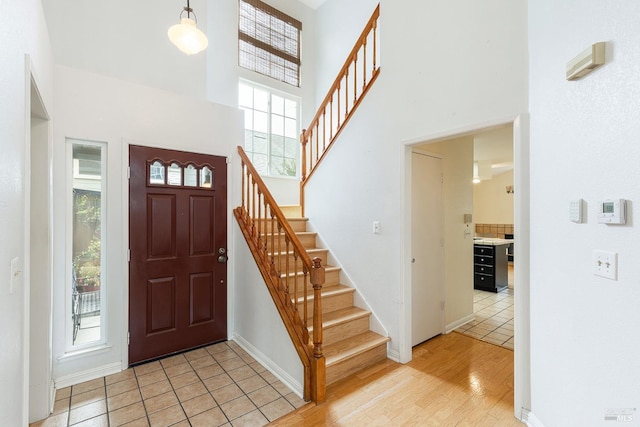 tiled foyer entrance featuring a towering ceiling