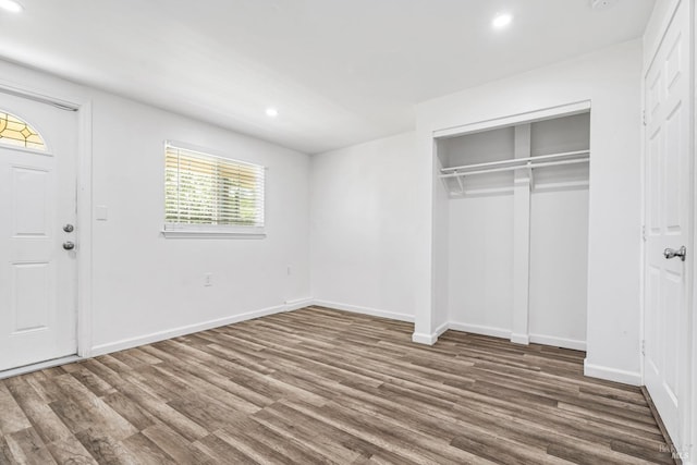 unfurnished bedroom featuring dark hardwood / wood-style flooring and a closet