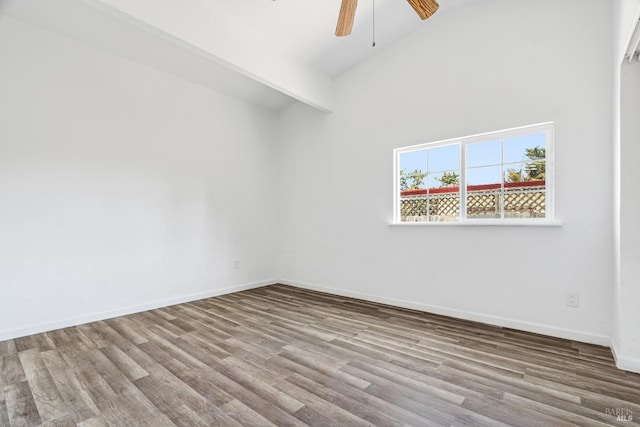 empty room with ceiling fan, beamed ceiling, hardwood / wood-style floors, and high vaulted ceiling