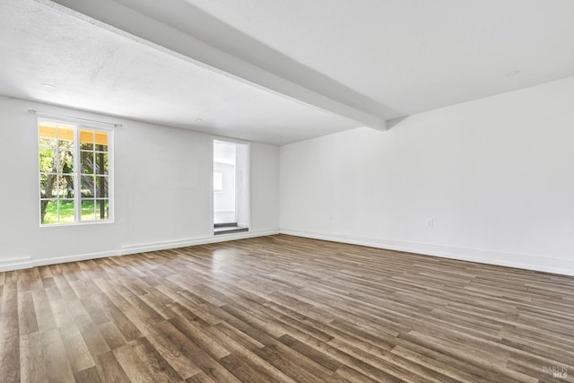 unfurnished room featuring beam ceiling and hardwood / wood-style floors