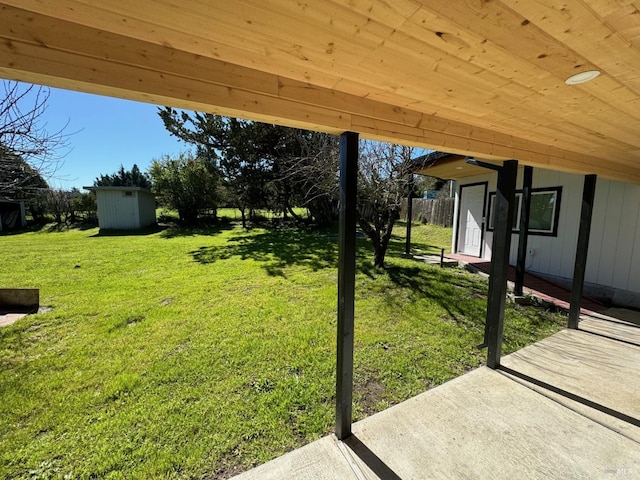 view of yard featuring a shed and a patio area