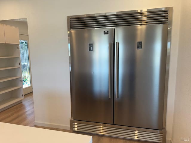 room details with wood-type flooring and stainless steel built in fridge