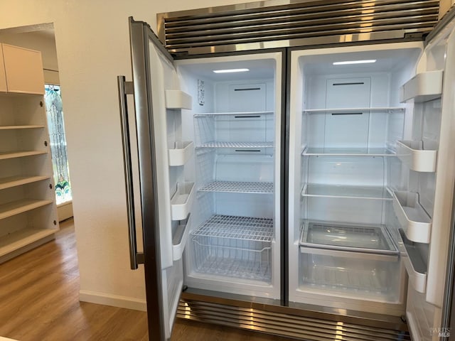 room details with wood-type flooring and built in fridge