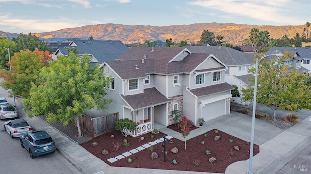 exterior space with a mountain view, a porch, and a garage