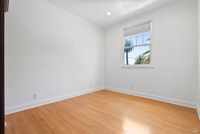 unfurnished room with light wood-type flooring and ornamental molding