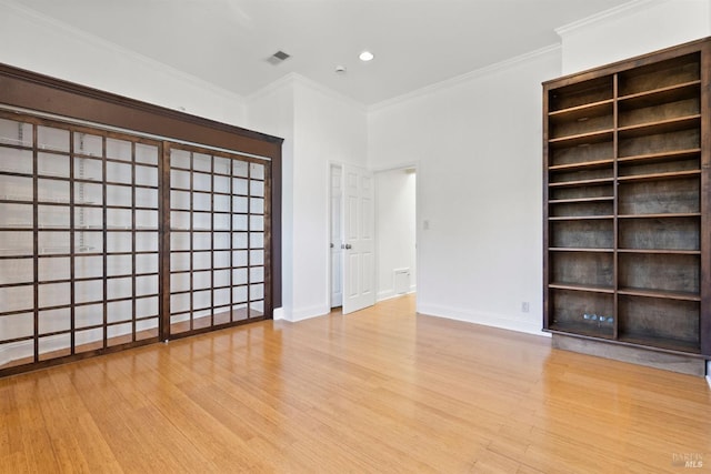 empty room with light wood-type flooring and crown molding