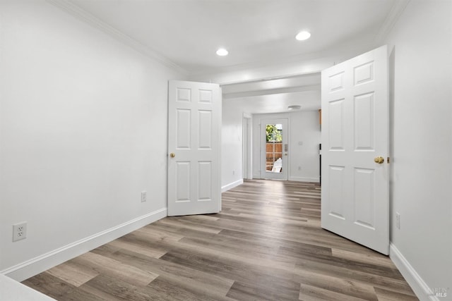 unfurnished room with ornamental molding and wood-type flooring