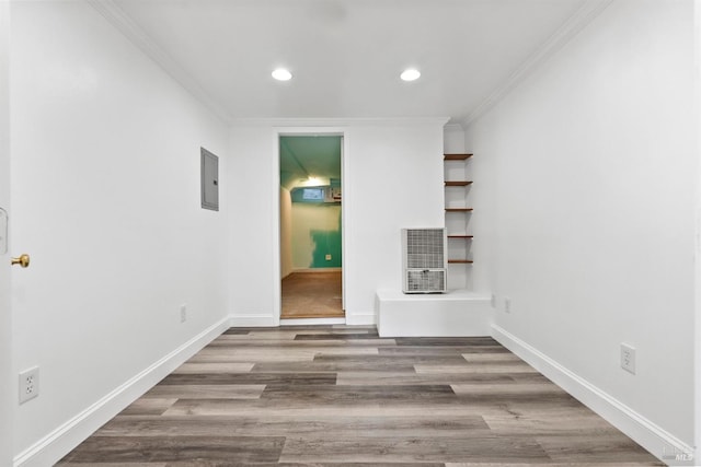 interior space featuring wood-type flooring, electric panel, and crown molding