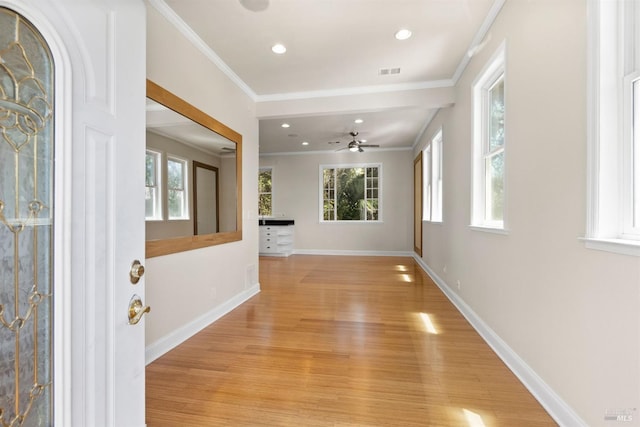 corridor with light wood-type flooring and crown molding