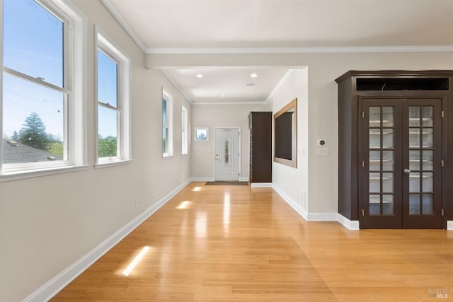 entrance foyer featuring french doors, light hardwood / wood-style flooring, and ornamental molding