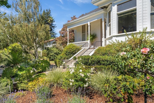 exterior space featuring covered porch and stairway