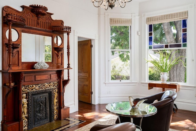 sitting room with an inviting chandelier, a fireplace with flush hearth, and wood finished floors