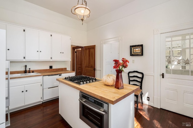 kitchen with wooden counters, dark wood-style flooring, appliances with stainless steel finishes, a sink, and white cabinets