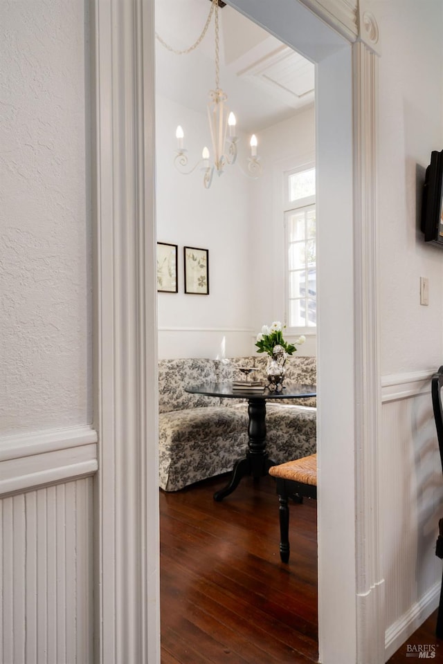 corridor featuring dark wood-style flooring and a chandelier