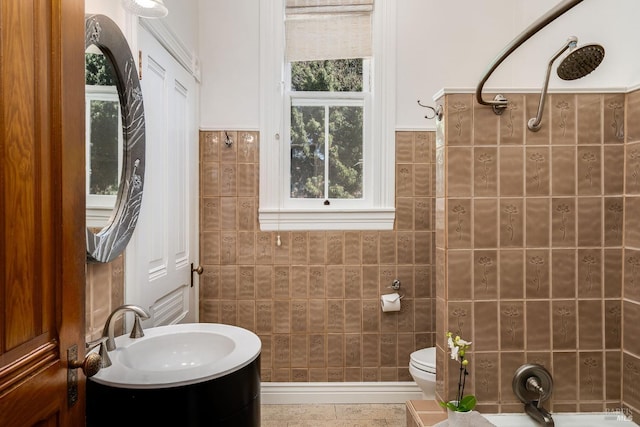 bathroom featuring toilet, tile walls, and plenty of natural light