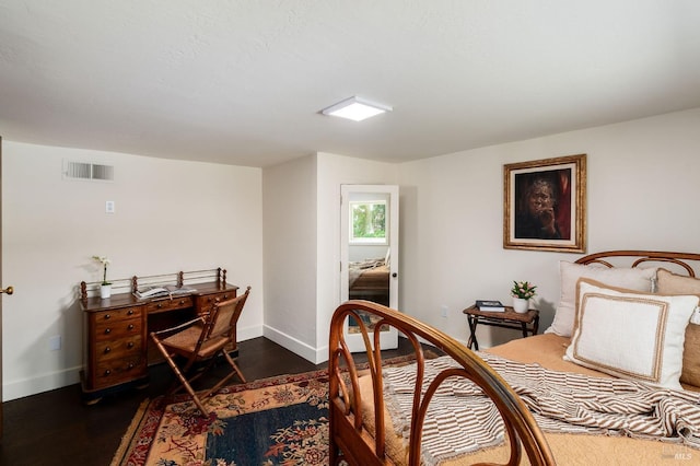 bedroom with baseboards, dark wood finished floors, and visible vents