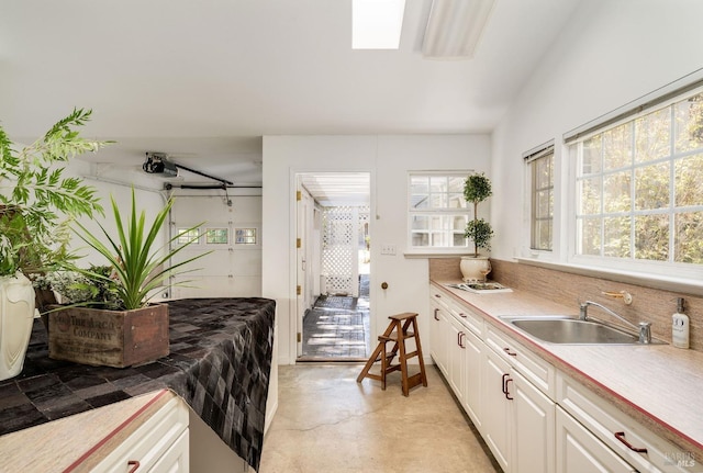 kitchen featuring a sink, white cabinetry, and light countertops