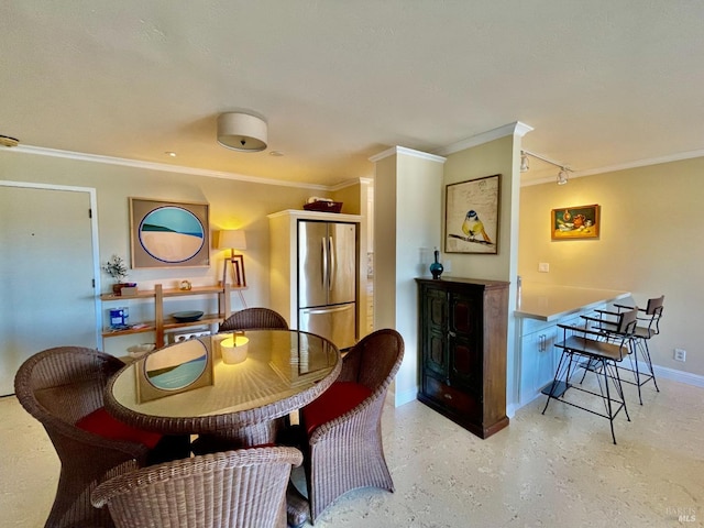 dining space with rail lighting, crown molding, and baseboards