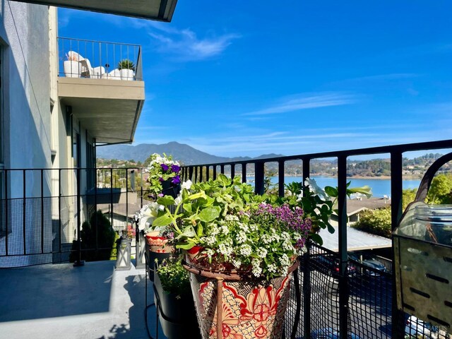 balcony featuring a water and mountain view