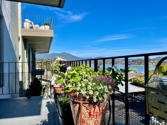 balcony featuring a water and mountain view