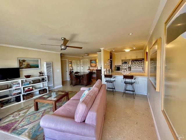 living room with ornamental molding, sink, and ceiling fan