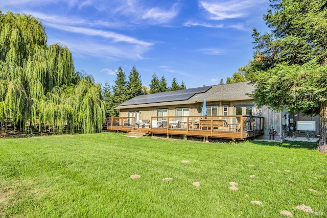 back of property with a lawn and a deck