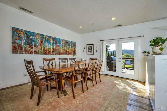 dining space with light wood-type flooring and french doors