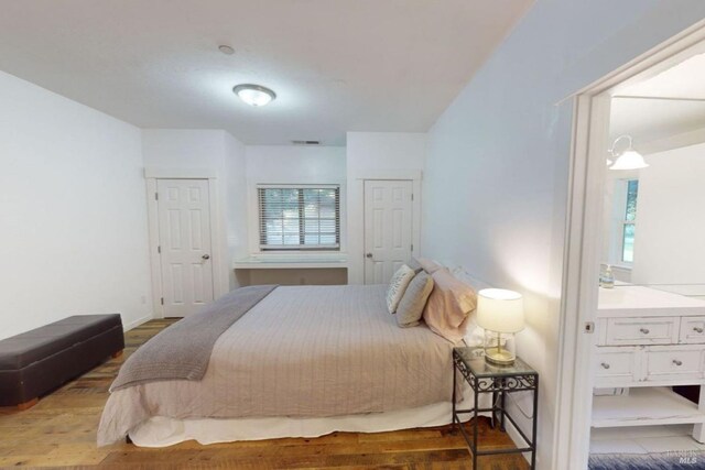 bedroom featuring hardwood / wood-style flooring and multiple windows