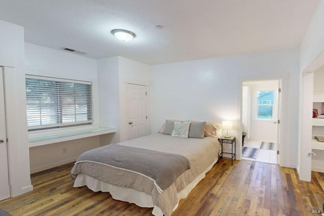 bedroom with dark hardwood / wood-style floors