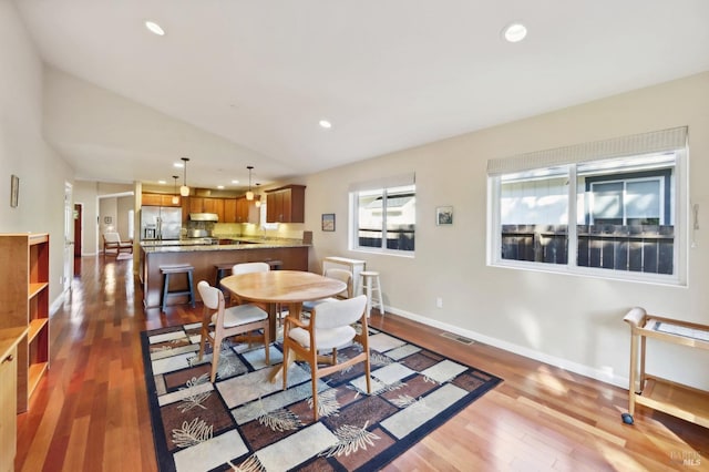 dining room featuring wood-type flooring and lofted ceiling