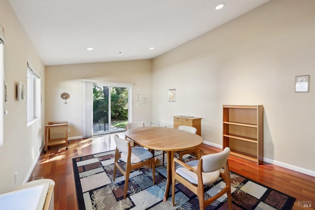 dining area featuring lofted ceiling and hardwood / wood-style flooring