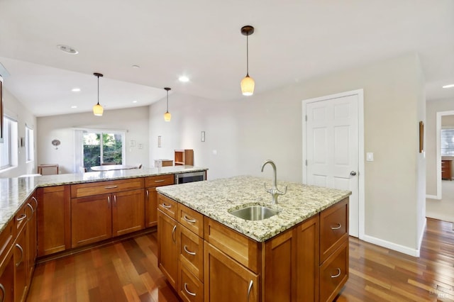 kitchen featuring pendant lighting, sink, light stone countertops, and dark wood-type flooring