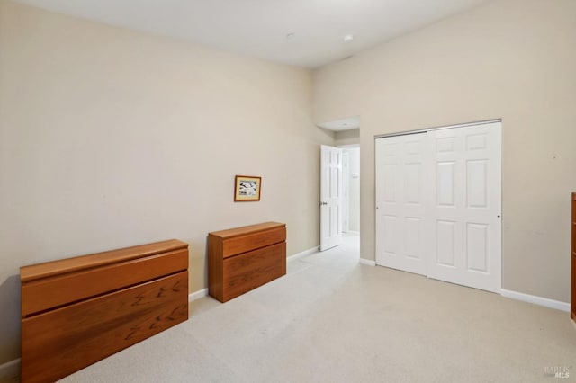 carpeted bedroom featuring a high ceiling and a closet