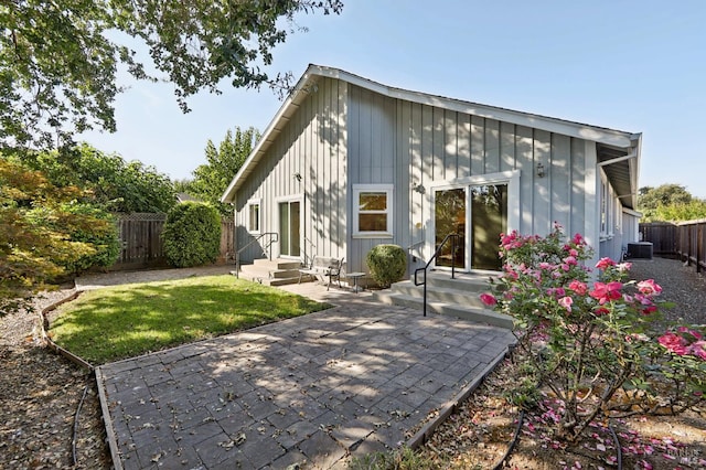 back of property with central AC unit and a patio area