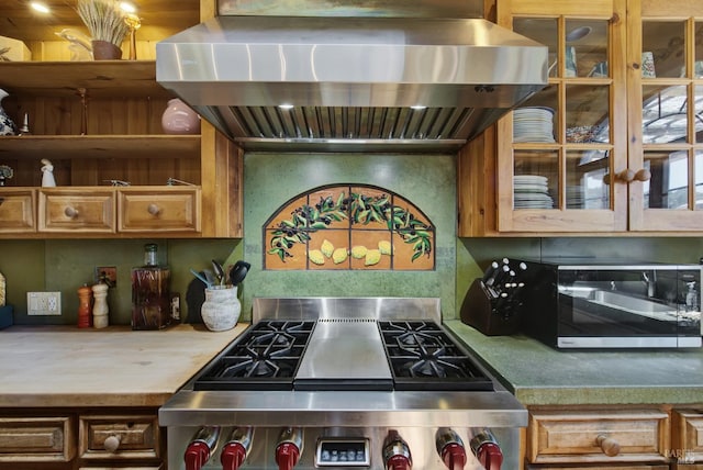 kitchen with appliances with stainless steel finishes and wall chimney range hood