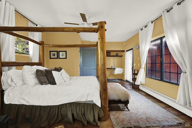 bedroom with ceiling fan, baseboard heating, and tile patterned floors