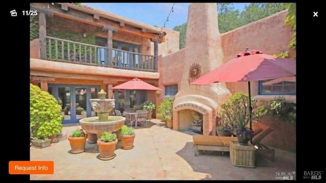 back of property with a balcony, french doors, and a patio area