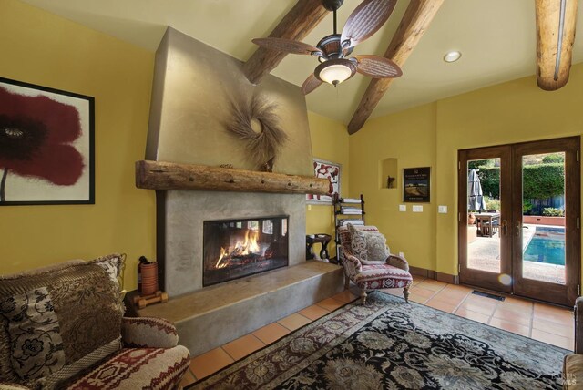 living room with ceiling fan, beamed ceiling, light tile patterned floors, french doors, and a premium fireplace